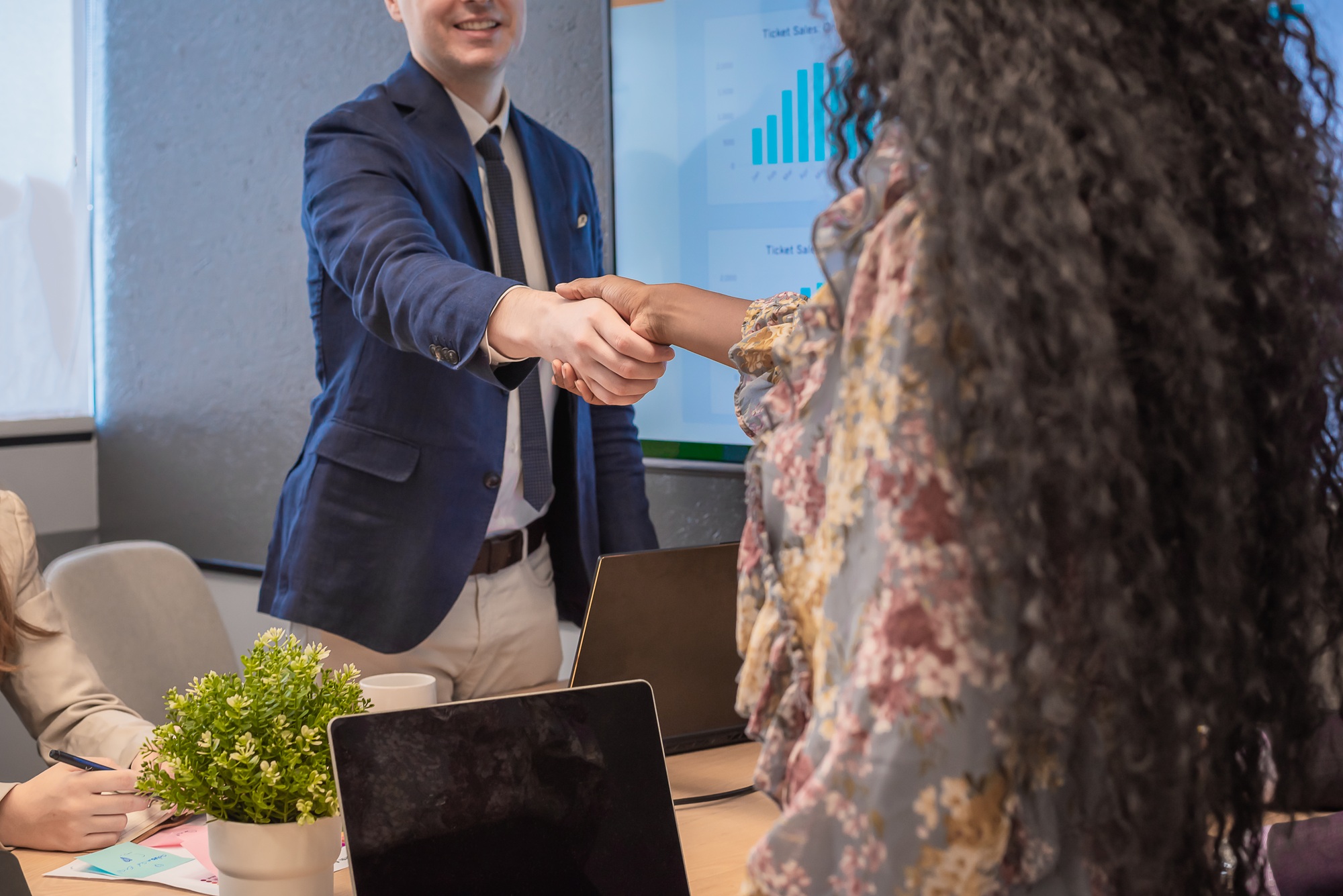 Business man shake hands with business women agreeing on partnerships or introducing themselves